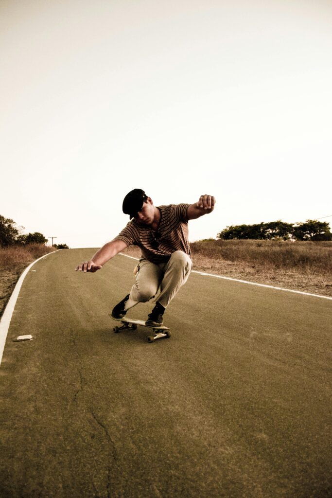 A skateboarder performing a trick on a deserted road at sunset, showcasing motion and balance.